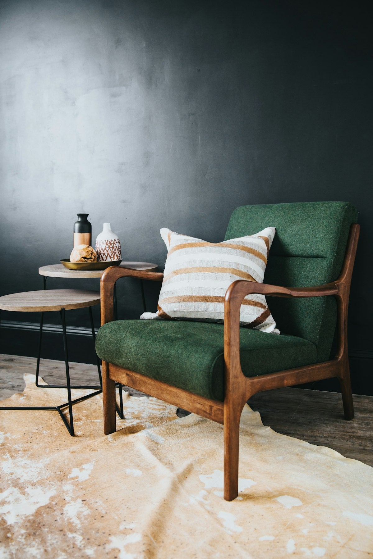 Ivory and ochre striped throw pillow on a green armchair