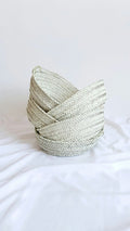 Stack of handwoven palm baskets in sage and natural weave