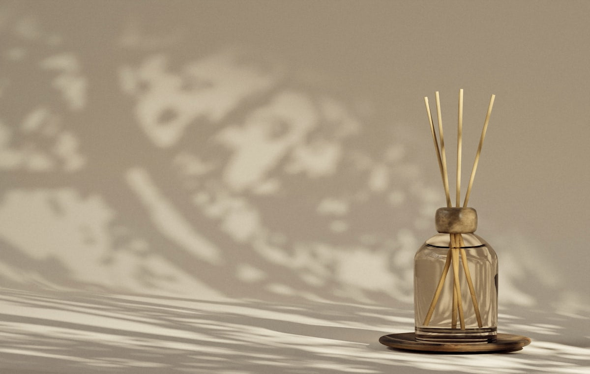 Amber glass reed diffuser with natural rattan reeds in soft light
