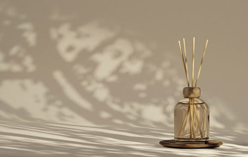 Amber glass reed diffuser with natural rattan reeds in soft light